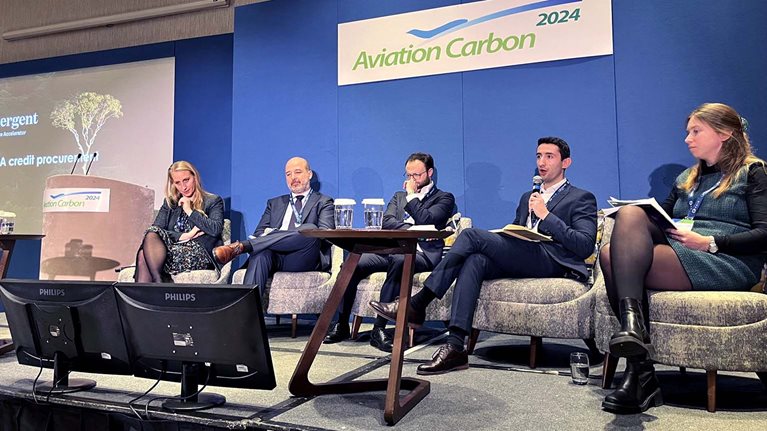 Craig Stock, with microphone, speaking at a conference about sustainable aviation